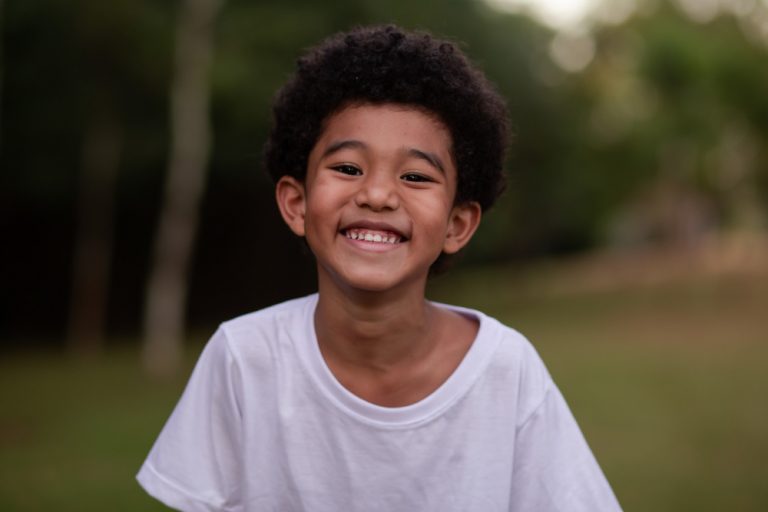 little-afro-boy-smiling-camera-park